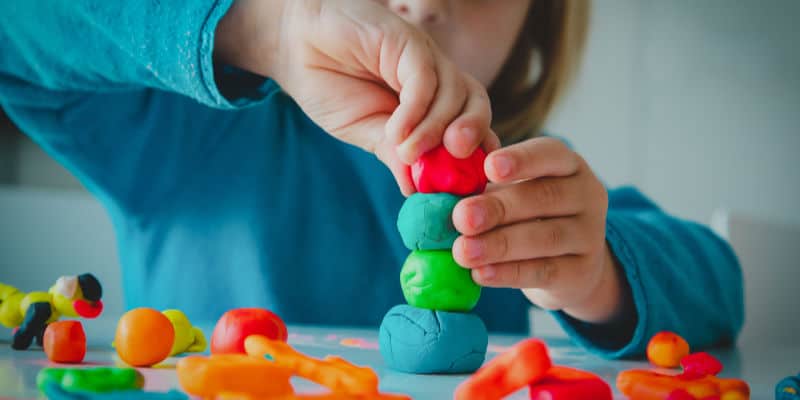 child playing screen free activity inside on table with play dough