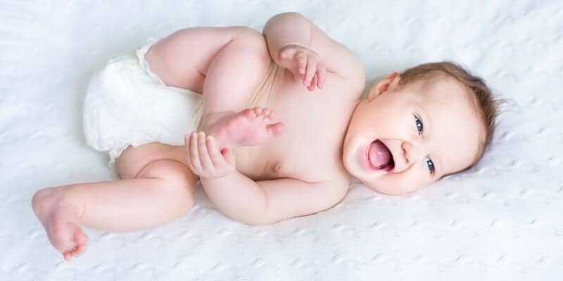 baby laughing on a bed