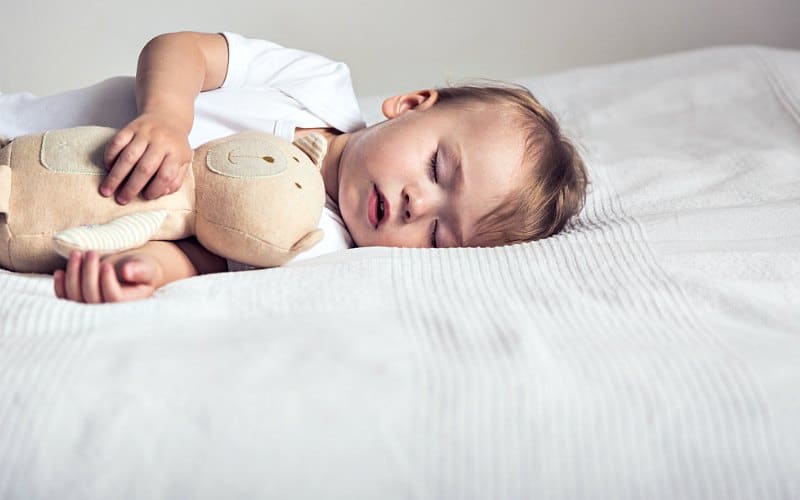 little boy sleeping with a teddy bear