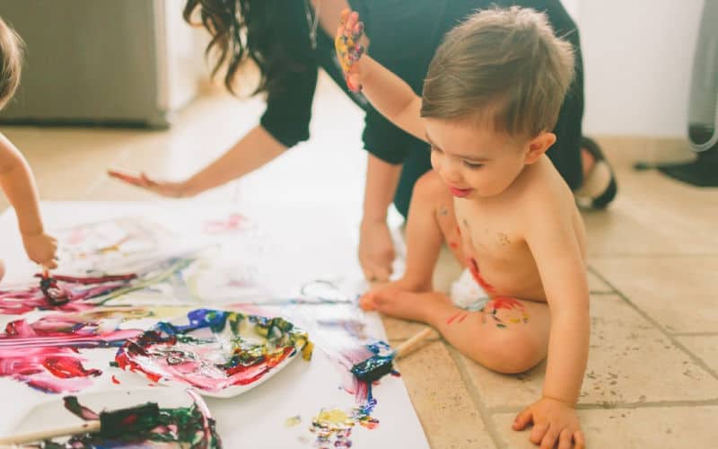screen free activity toddler is painting on floor with mom at home