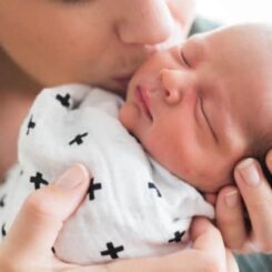 newborn baby sleeping in his moms arms on a newborn sleep schedule