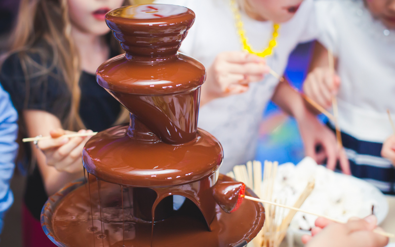 Kids celebrate New Year's Eve kid friendly with chocolate fountain. 