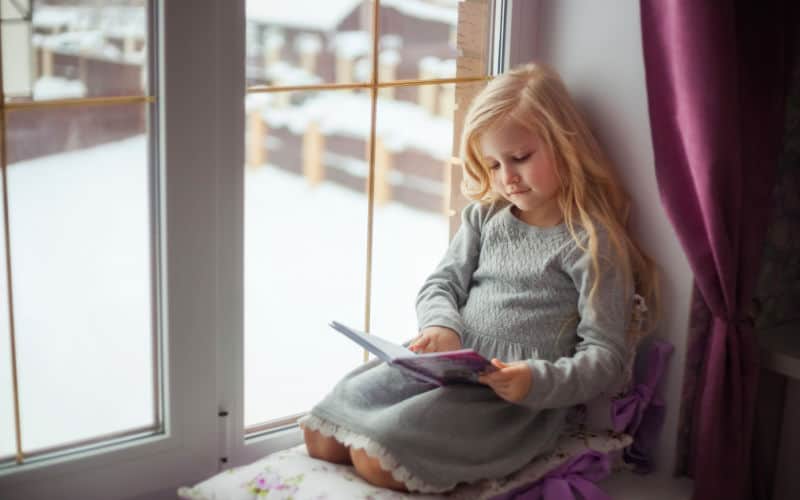 little girl reading cozy book