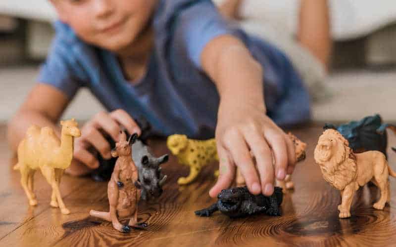 child doing play therapy at home with animal toys
